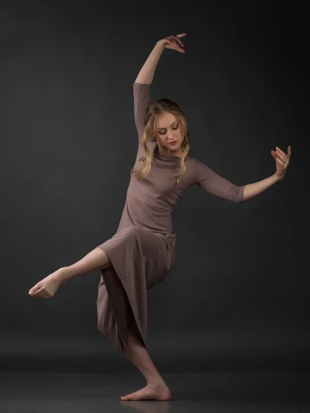 Dancer. Contemporary dance. Beautiful elegant woman dances on gray background