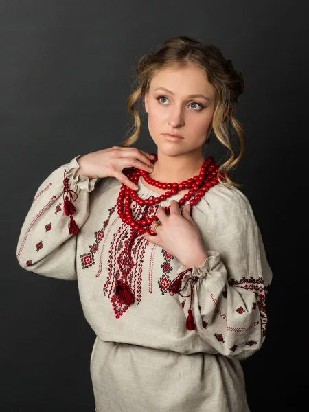 Beautiful serious young woman in Ukrainian embroidery