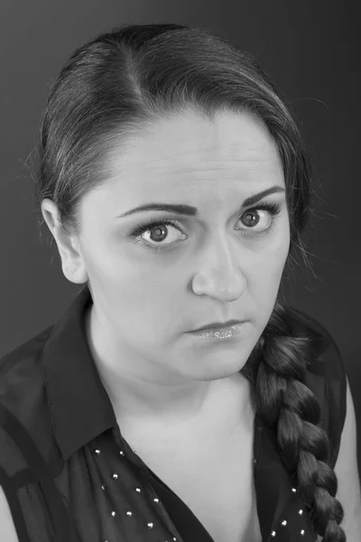 Upset serious girl on a gray background. Black and White Photo