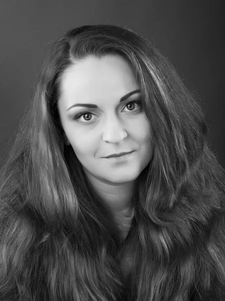 Portrait of a cute woman with a neat day make-up on a gray background. Black and White Photo