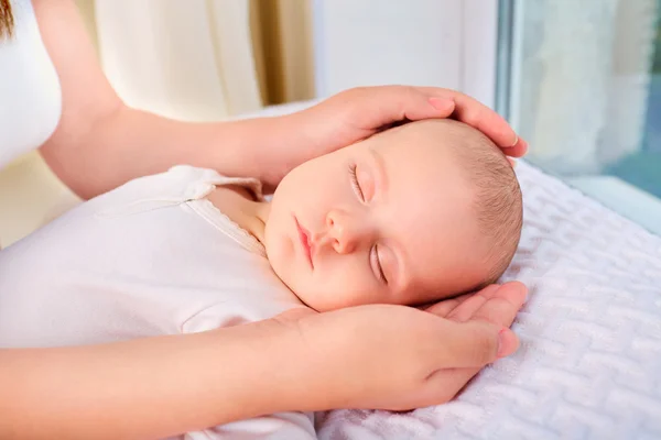 Loving mom hand holding cute sleeping newborn baby child.Mother