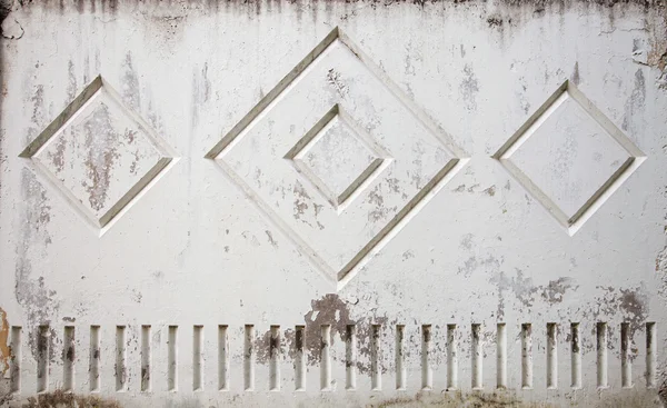 Old worn out stained shabby rough concrete gray fence wall with geometric square pattern background