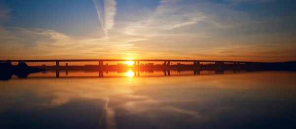 Urban sunset, bridge and mirroring water