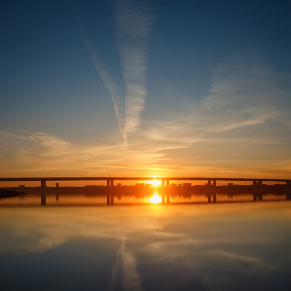 Urban sunset, bridge and mirroring water