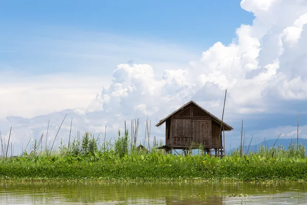 Bamboo hut on the lake on a background of blue cloudy sky