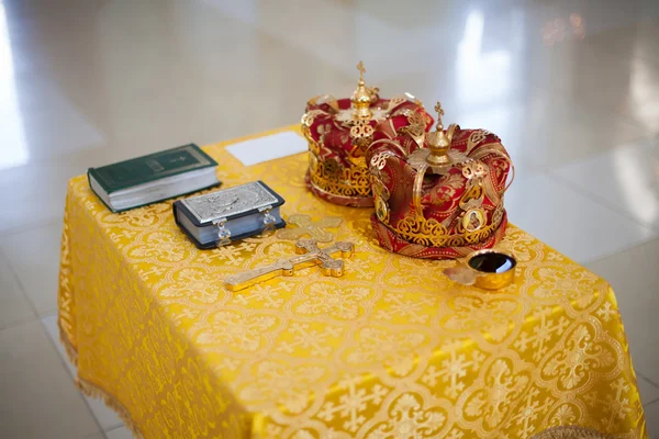 Orthodox Church wedding paraphernalia on table - cross, bible and crowns