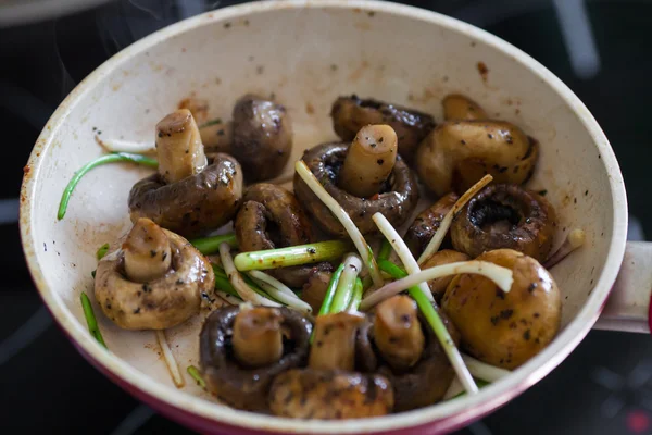 Roasted field mushrooms, champignons being cooked in frying pan