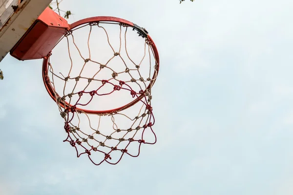 Red basketball hoop with nice blue sky.