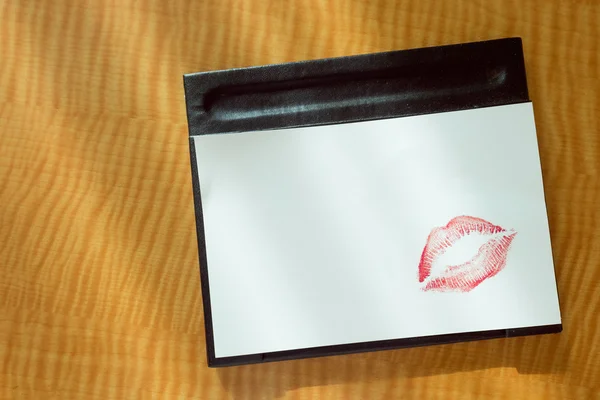 Red lips kiss, Love you write on white note on table