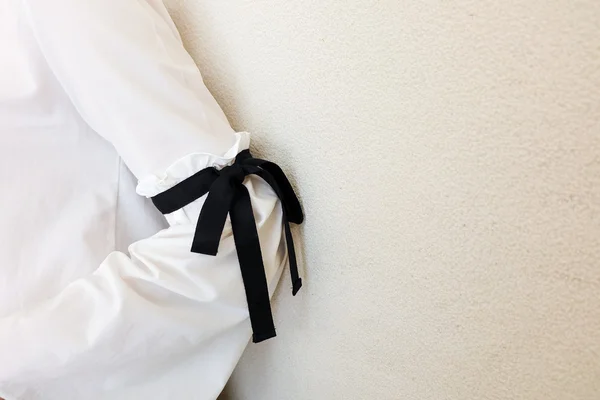 Long white sleeve with black string bow tie style details. Close up trendy fashion.