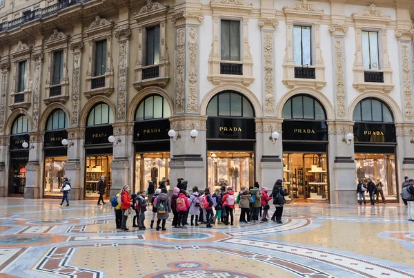 MILAN, ITALY - DECEMBER 10, 2014: Group of children with teacher tour in Luxury Store at Galleria Vittorio Emanuele II shopping mall in Milan