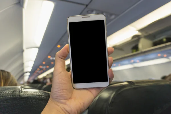 Woman using smartphone at the plane  - blurry background