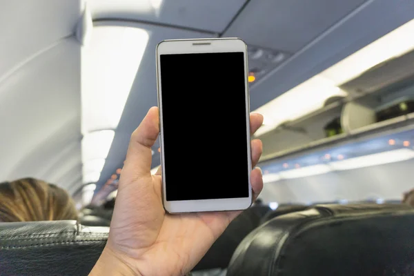 Woman using smartphone at the plane  - blurry background