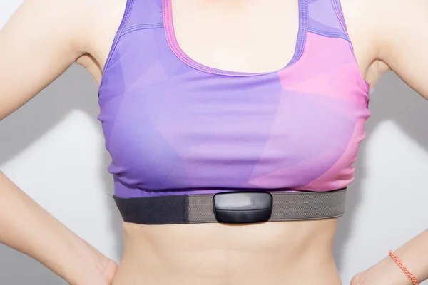 Woman in sport bra and heart rate monitor with tape isolated on