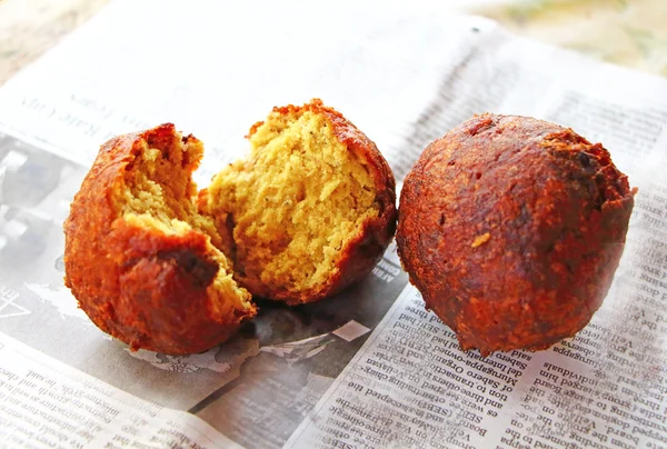 Street food. South India. Fried banana balls on a newspaper