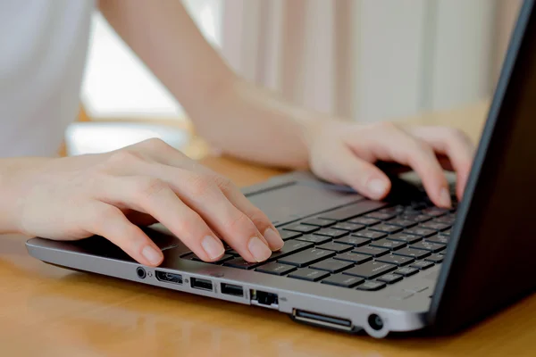 Programmer\'s hand typing with laptop. focus on his finger