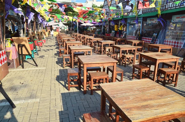 Bekasi, West Java, Indonesia. May 12 2015. Row of wooden tables & chairs in a street culinary festival