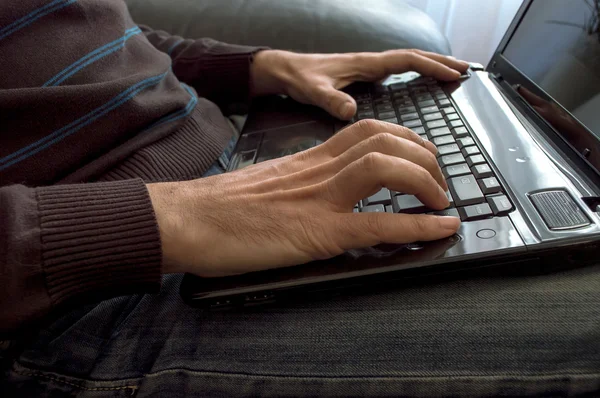 Man\'s hands on laptop keyboard