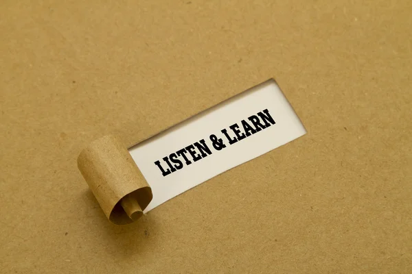 The phrase Listen and Learn written under torn paper.