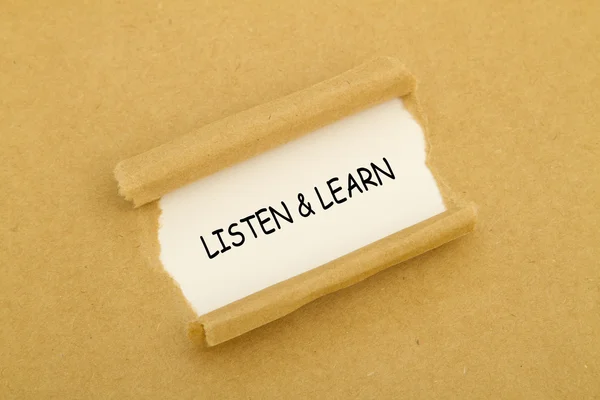 The phrase Listen and Learn written under torn paper.