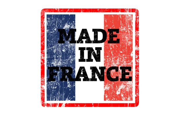MADE IN FRANCE word written on red rubber stamp and flag with grunge edges.