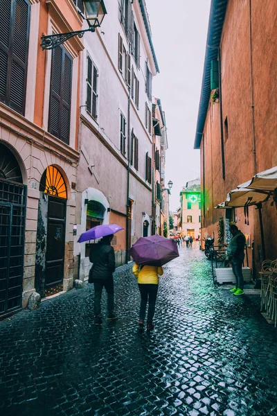 People with umbrellas in Rome
