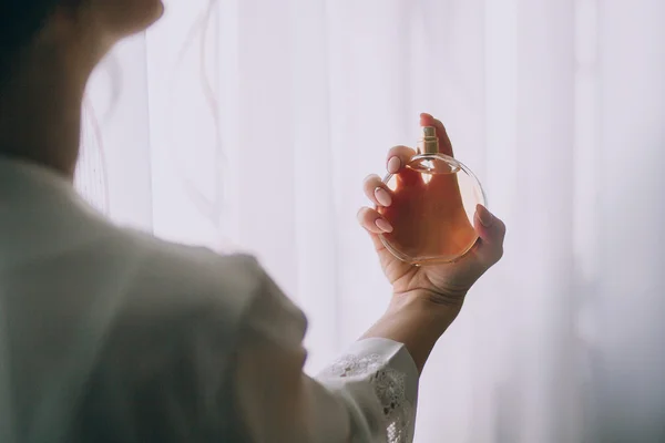 Hands of the bride with perfume