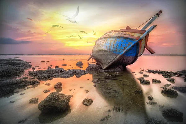 Fishing boat capsize at twilight background with flying birds, sea sunset, natural background