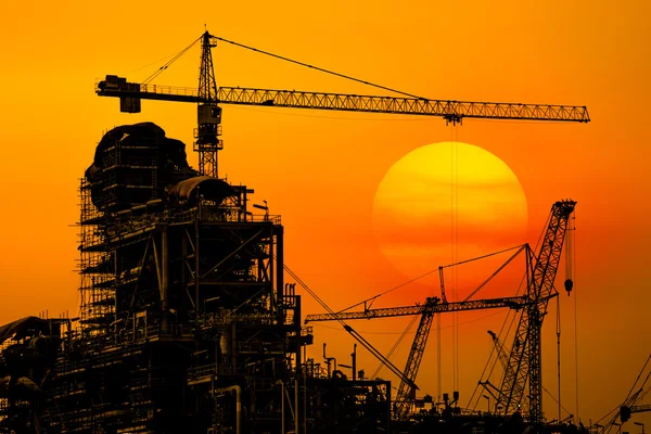 Oil refinery construction in silhouette, Industrial Oil refinery in building on sunset background at industrial plants.