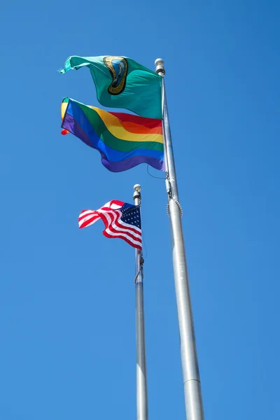 American, State of Washington, and Gay Pride flags in breeze