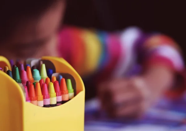 Colors crayons box. Coloring child on background.
