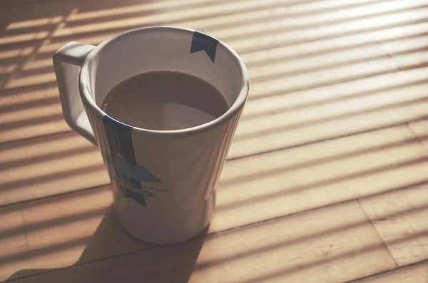 Cup of Coffee in Sun Lights on Wood Table