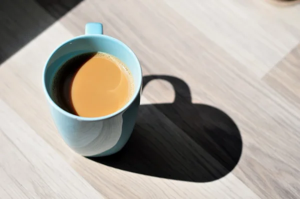 Cup of Coffee on Wood Table in Sun Lights