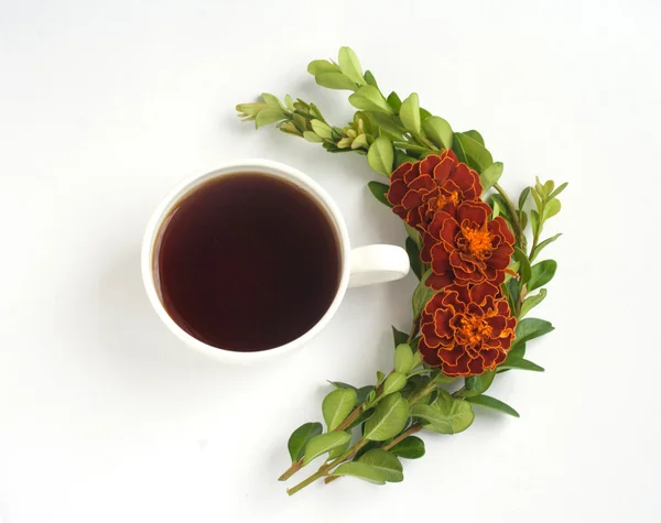 Still life with cup of coffee and flowers. Sprigs of boxwood and flowers tagetes