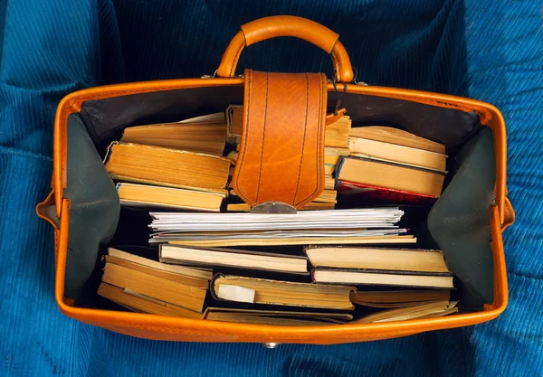 Stack of hardback books in an old suitcase with.