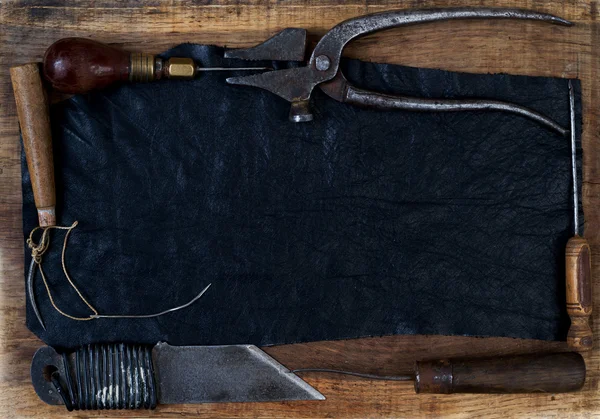 Leather craft tools on a wooden background. Craftmans work desk.