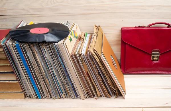 Retro styled image of a collection of old vinyl record lp\'s with sleeves on a wooden background. Top view.  Copy space