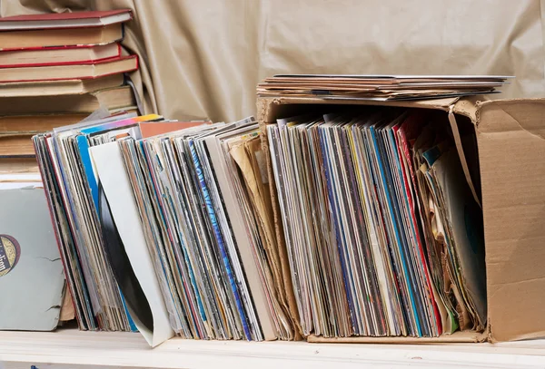 Retro styled image of a collection of old vinyl record lp\'s with sleeves on a wooden background. Top view.  Copy space
