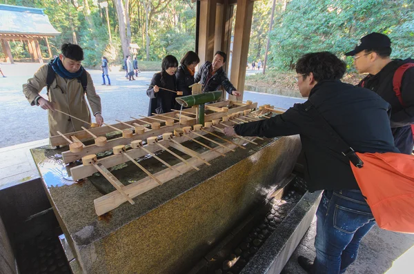 Tokyo, Japan - January 26, 2016: Unidentified people rinse hands and mouth at Temizuya. Temizuya is a Shinto water ablution pavilion for a ceremonial purification rite known as temizu.