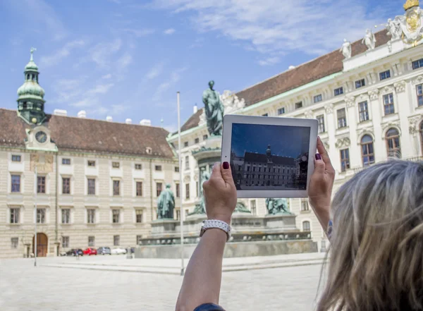 Woman making a picture of a building in Hofburg, Vienna, Austria