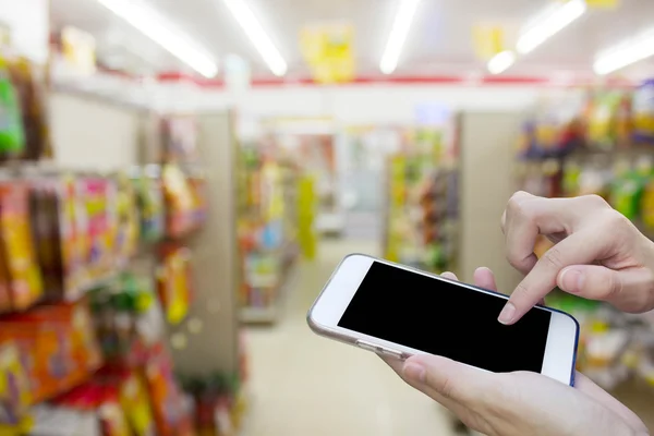 Woman using touch screen mobile phone with blur shopping mall