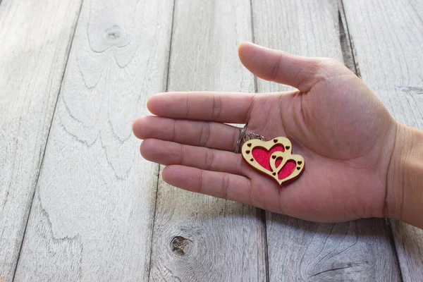 Heart Keychain in hand on wood table
