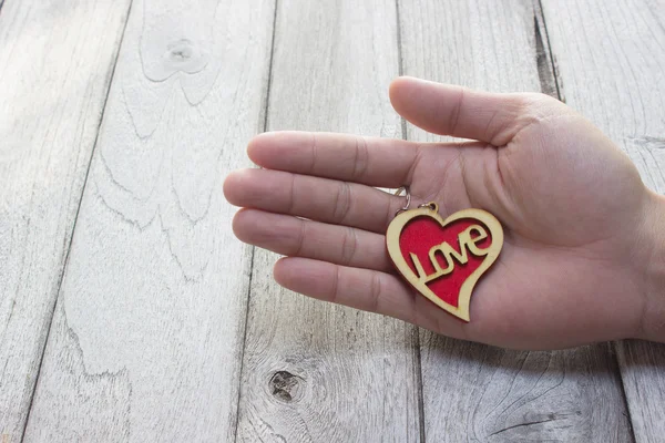 Heart Keychain in hand on wood table