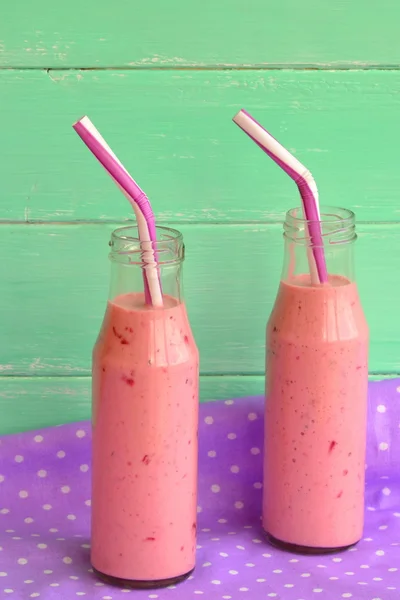 Fresh berry smoothies on mason jars with a straw