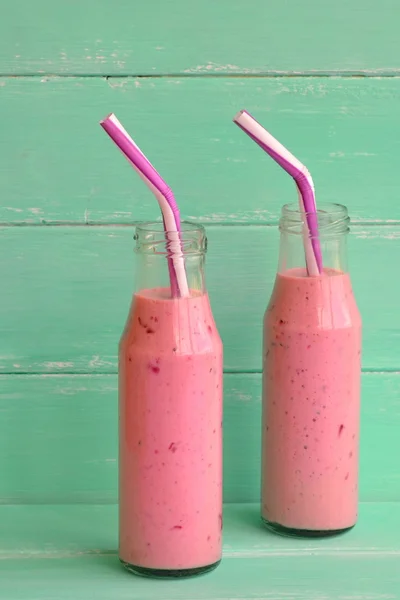Fresh berry smoothies on mason jars with a straw. Vegetarian food concept