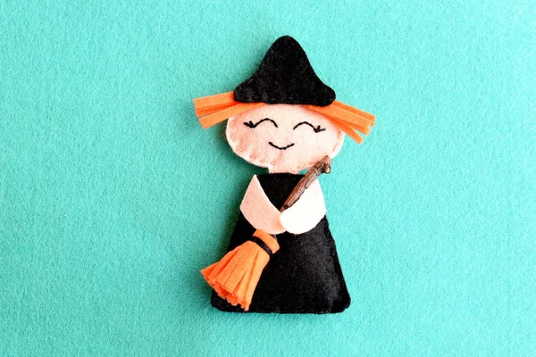 Halloween witch doll isolated on a blue felt background. Homemade cute witch crafts idea for kids. Halloween decor toy instructions step. Top view. Closeup