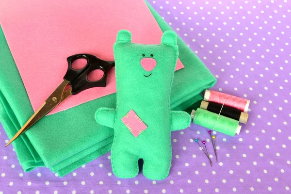 Cute green felt Teddy bear - handmade children bear toy. Scissors, threads, needles - sewing kit