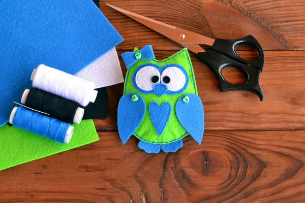 Felt owl embellishment. How to make a cute felt owl toy - kids crafts tutorial. Sheets of colored felt, scissors, thread, needle, wooden table