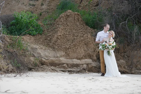 Young couple; bride; groom; at the sand shore; married couple;