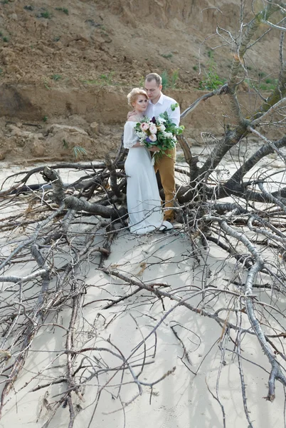 Young couple; bride; groom; at the sand shore; married couple;